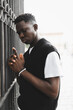 © Agata25 - Young African man outdoor, street portrait. Hands holding gun pose
