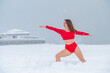 © Михаил Решетников - Caucasian woman dressed in red shorts and top doing yoga outdoors in winter.