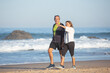 © KAMPUS - Senior couple calmly walking together. Happy Caucasian man and attractive woman in sportswear holding hands talking strolling along seashore. Spending time and active rest together concept