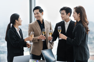 group of Asian business people holding glasses of wine to celebrate new year