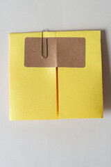 Sticker - plain brown paper sticker on yellow construction paper that has been folded and held in place with clip