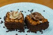 Closeup of two pieces of delicious brownie with manjar and chocolate on top on a white plate