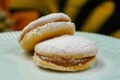 Closeup of two tasty cookies filled with manjar and sprinkled with powdered sugar