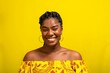 Portrait of happy young Afro-Brazilian woman smiling against a yellow background