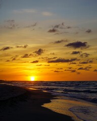 Wall Mural - Vertical view of a romantic sunset sky over a sandy beach and sea in Saint George Island, Florida