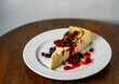 Closeup shot of a delicious cheesecake slice with berries as a topping served on a white plate