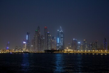 Canvas Print - Dubai city skyline at night with water in front