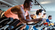 © Kzenon - African man and friends exercising on fitness bike in gym