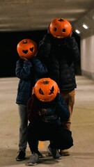 Canvas Print - Vertical shot of friends wearing curved pumpkins on their heads