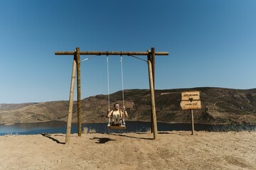 Caucasian male swinging on the sandy of Lagos do Sabor in Miradouro de Sao Lourenco, Portugal