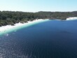 Aerial drone shot of the blue sea washing the sandy beach