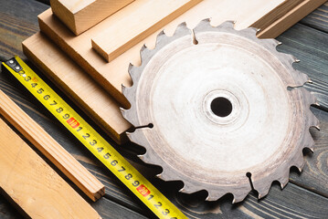 Wall Mural - Meter, wooden planks and circular saw blade on the carpenter workbench close up background.