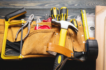 Construction work tools bag on the carpenter workbench top view background.