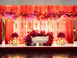 Front view of amazing Hindu wedding arch decorated by red flowers with white sofa for groom and bride, prepared for a traditional ceremony