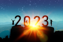 2022 2023 People Silhouette Man And Woman Hikers Standing Jump On A Big Stone At Sunset In Mountains.Raising Up Hands On High Rock In Evening Nature. Tourism, Traveling And Healthy Lifestyle Concept.