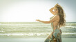 A bellydance dancer dancing to arabic music in front of a beach