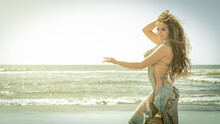 A Bellydance Dancer Dancing To Arabic Music In Front Of A Beach