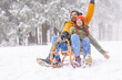 Couple having fun sledging while on winter vacation