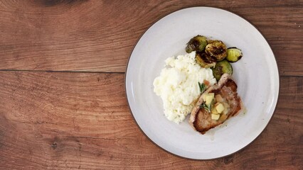 Wall Mural - Serving a Plate of Pork Chops with Apples and Brussel Sprouts