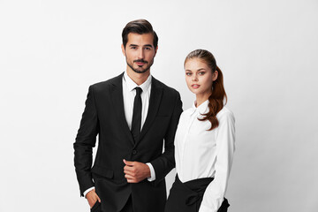 Wall Mural - Man and woman smile with teeth business in business attire looking into camera on white isolated background. Stylish business concept paired between employees startup copy space