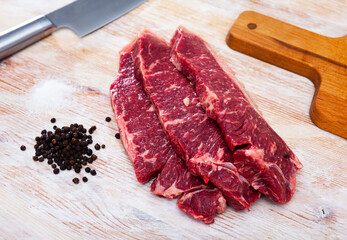 Wall Mural - Preparation of raw beef fillet with parsley and garlic on wooden cutting board