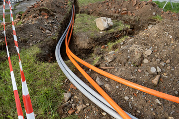Wall Mural - underground cable connecting infrastructure installation. Construction site with communication Cables protected in tubes. high speed Internet Network cables are buried on the street