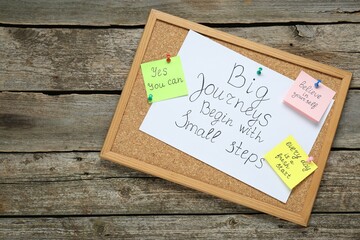 Wall Mural - Corkboard with motivational quotes on wooden table, top view