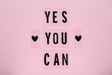 Phrase Yes You Can and hearts on pink background, top view. Motivational quote