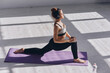 © gstockstudio - Top view of beautiful young woman doing stretching exercises while practicing in studio