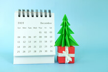 Selective Focus Of December 2022 Desk Calendar On Blue Background With Christmas Tree, Gift And Copy Space.	