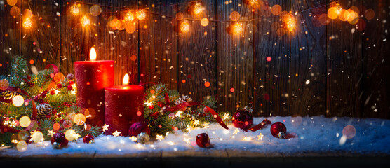 Christmas candles and lights.Red candles with ornament on table