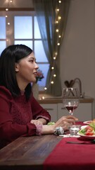 Wall Mural - Vertical Screen: asian wife with good communication talking at dinner table while spending cozy Christmas eve together at home decorated for the holiday celebration