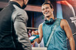 © Beaunitta V W/peopleimages.com - Men, credit card machine or payment in gym membership, personal trainer access or fitness coaching subscription. Banking device, nfc or cashless transaction or happy, smile or training sports athlete