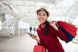 © krumanop - Beautiful Asian woman shows an ecstatic expression after shopping mall with shopping bag and smartphone. Ecommerce and Shopaholism.