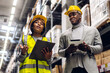 © Art_Photo - Portrait two african american engineer team shipping order detail on tablet check goods and supplies on shelves with goods inventory in factory warehouse.logistic industry and business export