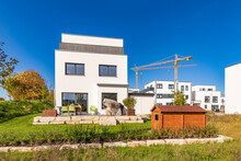 Germany, Baden-Wurttemberg, Weinstadt, Back Yard Of Modern Suburban House With Industrial Crane In Background