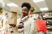 Smiling Woman Holding Gifts And Shopping Bags In Store