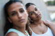 © Westend61 - Teenage girl with friend leaning on wall