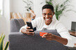 © Westend61 - Smiling woman lying on couch using mobile phone and credit card