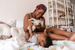 © Drobot Dean - Happy black mother putting on new diaper to her baby