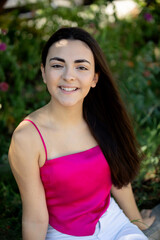 Wall Mural - Portrait of a happy lovely and beautiful Spanish young woman in a park.