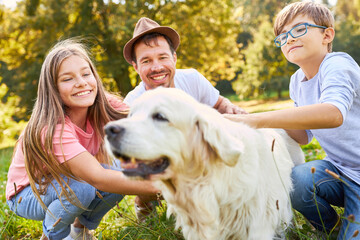 Wall Mural - Father and two children pet dog in park