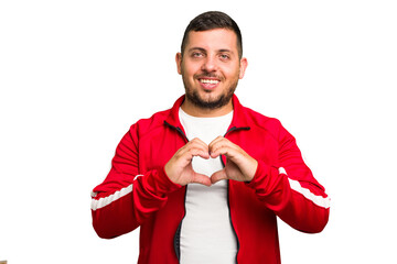 Canvas Print - Young caucasian man isolated smiling and showing a heart shape with hands.