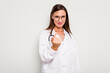 © Asier - Young doctor woman isolated on white background pointing with finger at you as if inviting come closer.