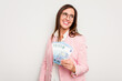 © Asier - Business caucasian woman holding banknotes isolated on white background looks aside smiling, cheerful and pleasant.
