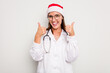 © Asier - Young caucasian doctor woman wearing a santa hat isolated on white background