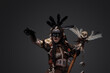 © Fxquadro - Shot of screaming dark wizard dressed in aboriginal attire against grey background.