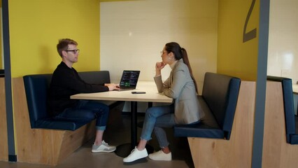 Wall Mural - Software developers having a discussion in a coworking office. Computer programmers working on a coding project. Two young business people working in tech.