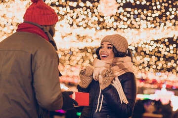 Poster - Photo of excited impressed husband wife wear winter season clothes geeting xmas gift outside urban city street