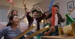 © ChayTee - Group of young adult friend man and woman asia people sit at sofa couch joy night party fun game FIFA world cup live TV at home eat snack bowl drink beer bottle glass jump mad happy win exult face